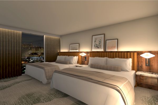 A modern hotel room with two beds, wooden headboards, and warm lighting, overlooking a cityscape at night through large windows.